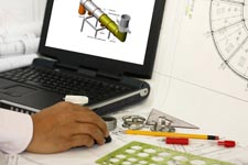 hands on desk with laptop and drawing instruments